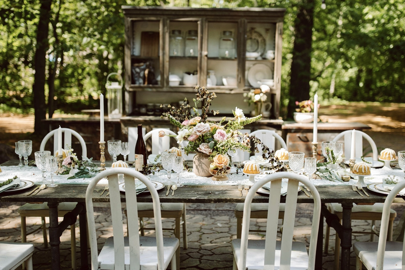 A table with white chairs and a wooden cabinet