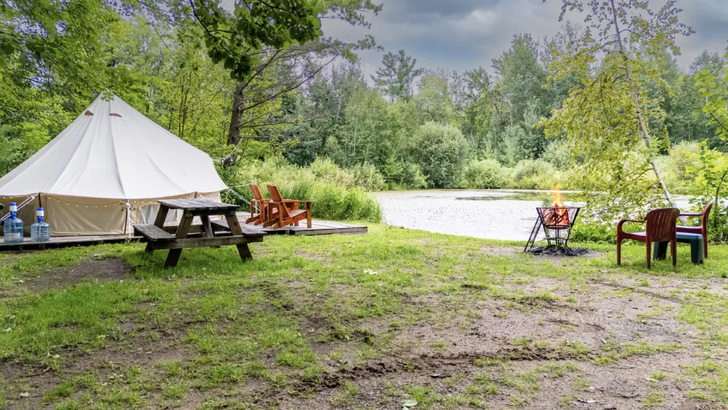 A picnic table and fire pit near the water.